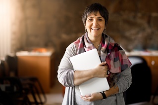 Frauke Conradi, Bild: www.moovly.com, nicht unter freier Lizenz Das Bild zeigt eine Frau mittleren Alters mit braunen Haaren und einer grauen Strickjacke, die freundlich in die Kamera schaut.