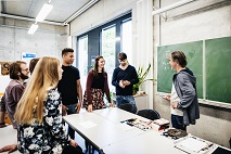 Das Bild zeigt einen Dozenten im Gespräch mit seinen Seminarteilnehmenden.