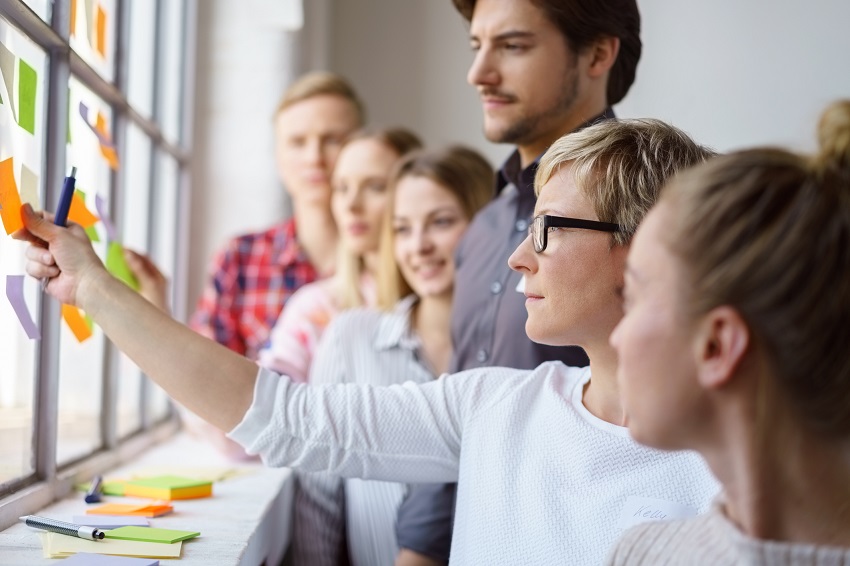 Das Bild zeigt eine Lerngruppe, die gemeinsam mit Haftnotizen arbeitet.